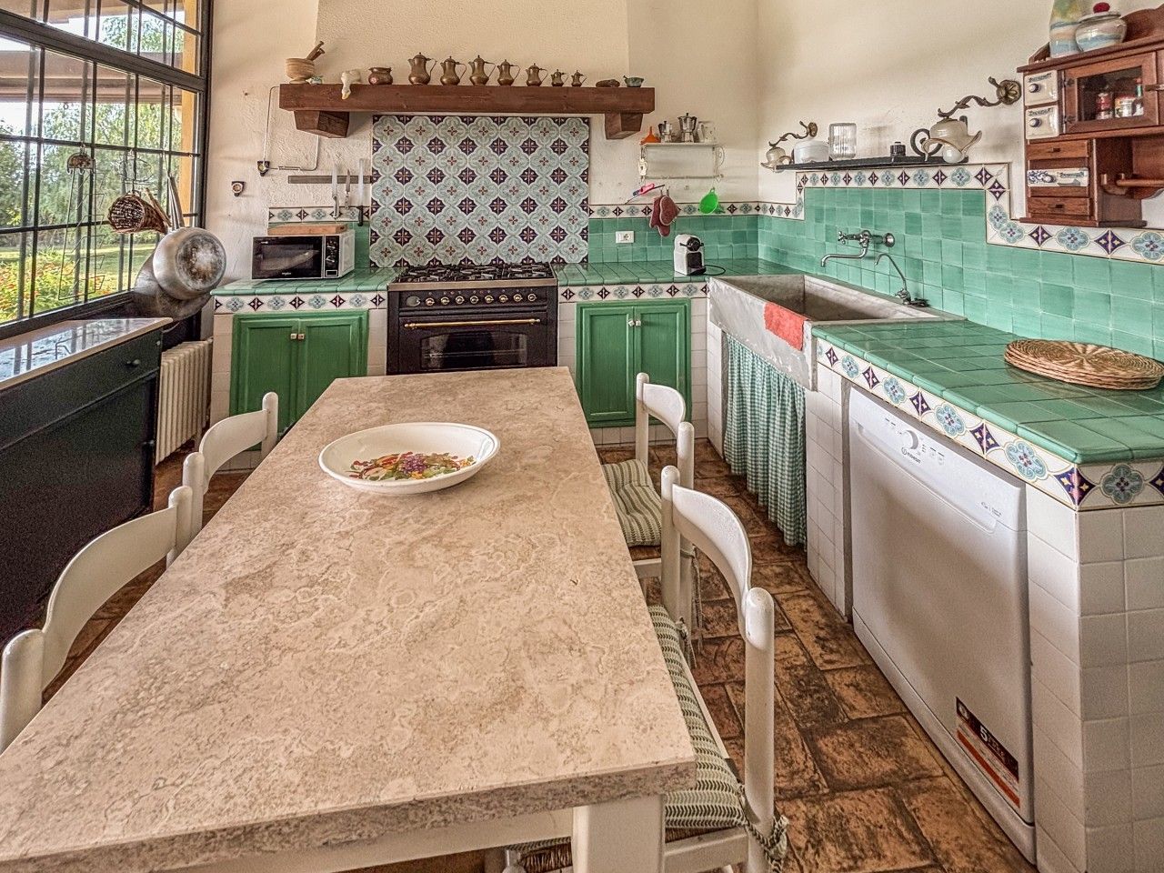 Una cocina con isla central, estufa y lavavajillas.