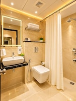 Un baño moderno con lavamanos, inodoro y ducha.