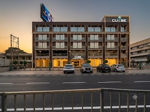 Un complexe commercial à plusieurs étages, reconnaissable à son grand panneau « CUBE », qui présente une architecture moderne avec de grandes fenêtres et un toit plat.