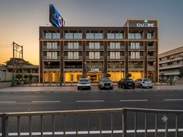 Un complexe commercial à plusieurs étages, reconnaissable à son grand panneau « CUBE », qui présente une architecture moderne avec de grandes fenêtres et un toit plat.