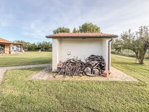 A small outdoor structure with a tiled roof, surrounded by a neatly trimmed lawn and a brick pathway. - Casal del Falco (Lazio)