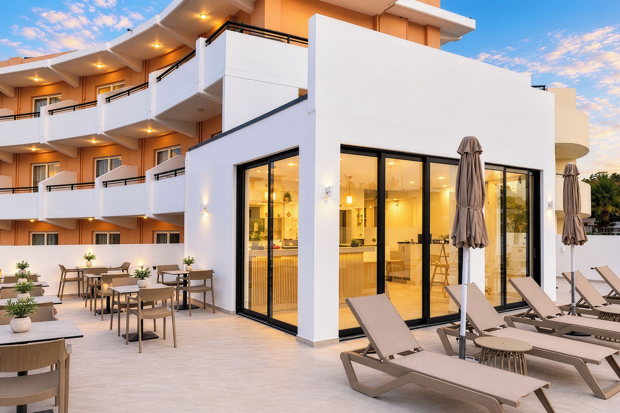 A modern hotel with outdoor seating and sun loungers.