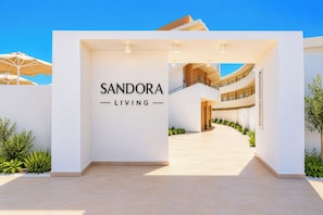 A modern building entrance with a sign reading 'SANDORA LIVING'. - Sandora Living Boutique Hote (Rhodes)
