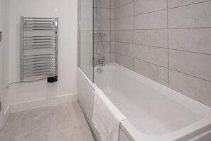 Ein modernes Badezimmer mit einer gläsernen Dusche, einer integrierten Toilette und einem an der Wand befestigten Handtuchhalter.