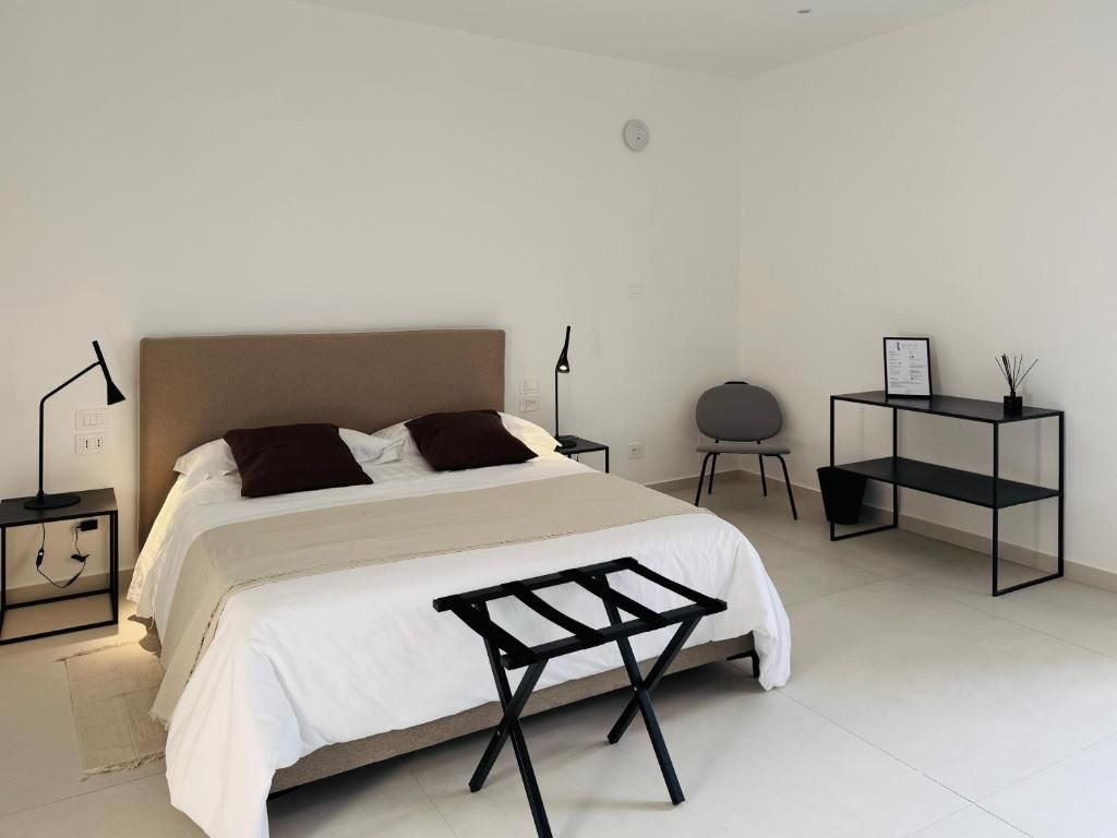 Ein Schlafzimmer mit einem Bett, Nachttischen, einem Sessel und einem Schreibtisch.