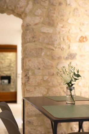A stone wall with a table and chairs. - Resalio Agriturismo di charme (Lazio)