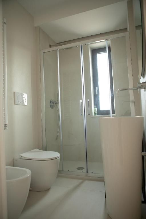 A bathroom with a toilet, a shower enclosure, and a bathtub.