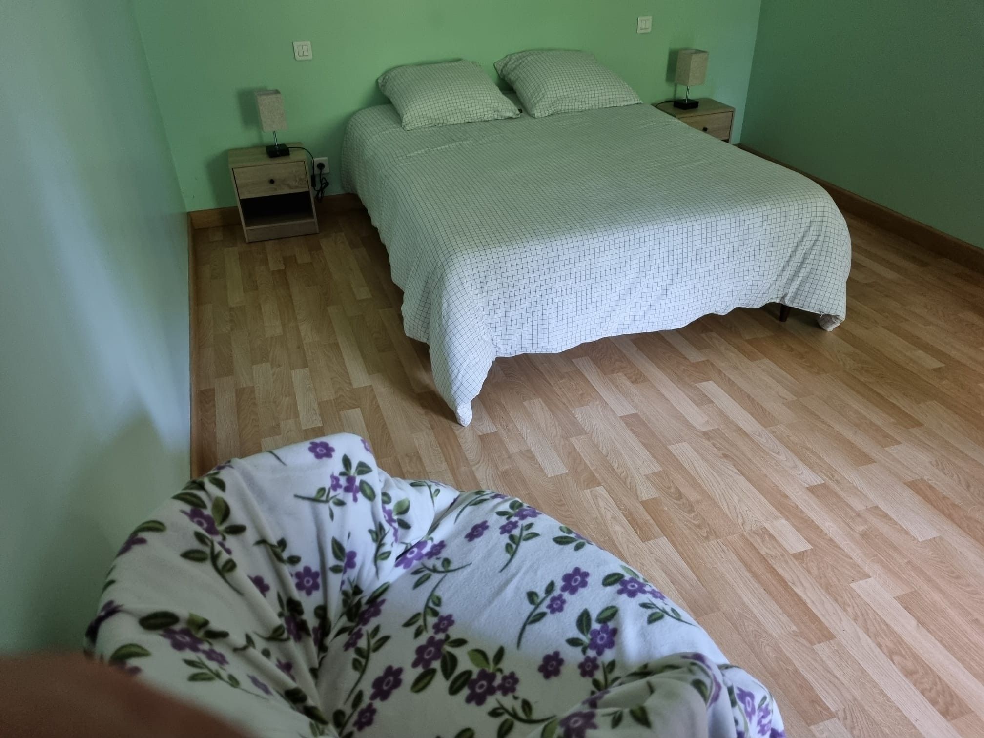 Une chambre à coucher avec un lit, deux tables de chevet et une commode.