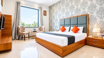 Habitación de hotel moderna con una cama grande, un escritorio y vistas al exterior.