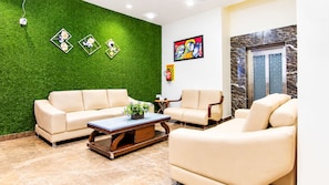 Una sala de estar moderna con una pared verde, dos sofás, una mesa de centro y una chimenea.