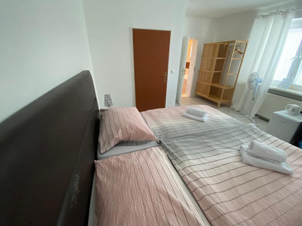 Un dormitorio con cama, armario y ventana con cortinas.