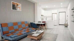 Una sala de estar moderna con un sofá, una mesa de centro y un comedor con sillas.