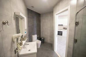 Un baño moderno con lavamanos, espejo y secador de pelo.