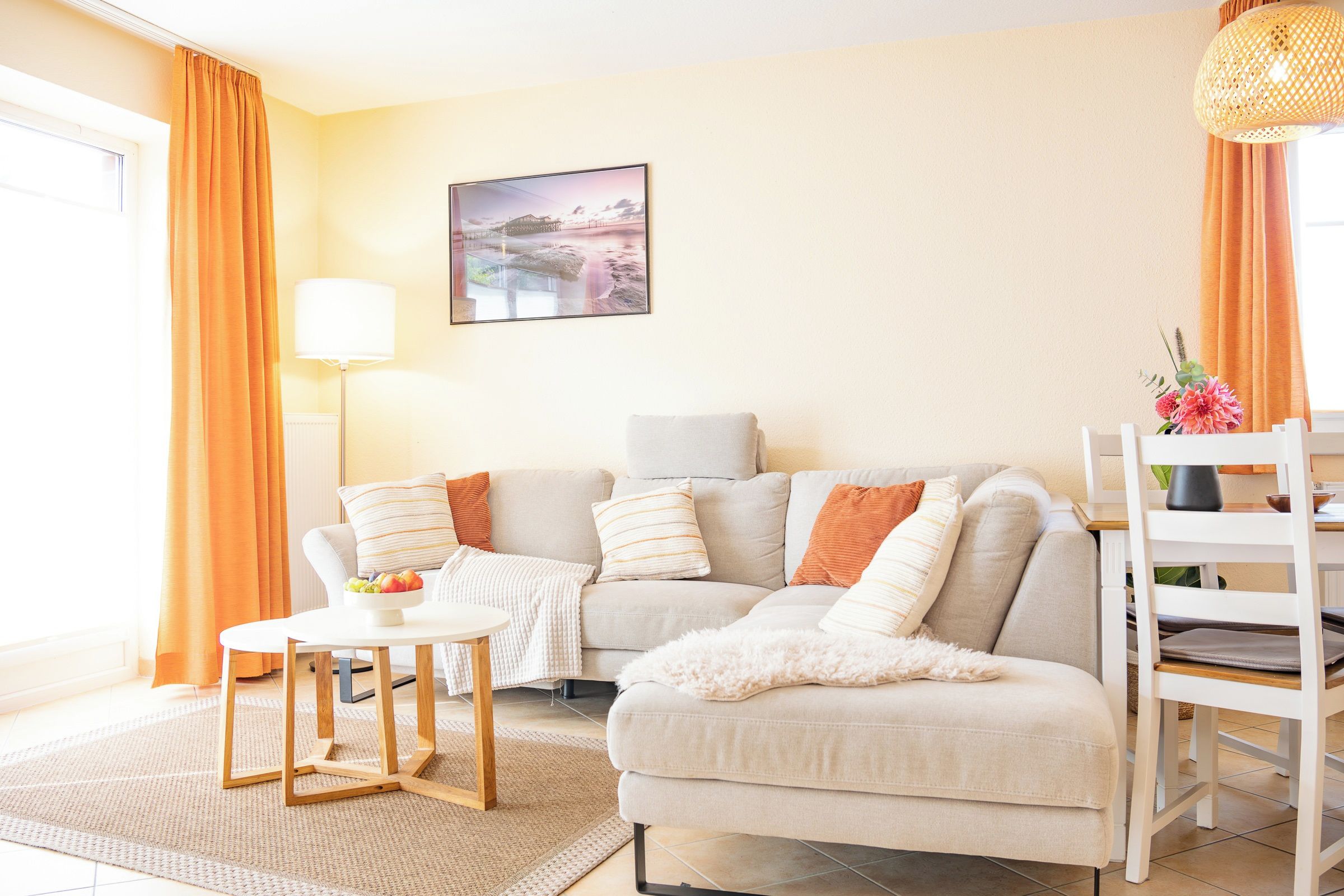 Ein Wohnzimmer mit einer Couch, einem kleinen Tisch, einer Lampe und einem Bild an der Wand.