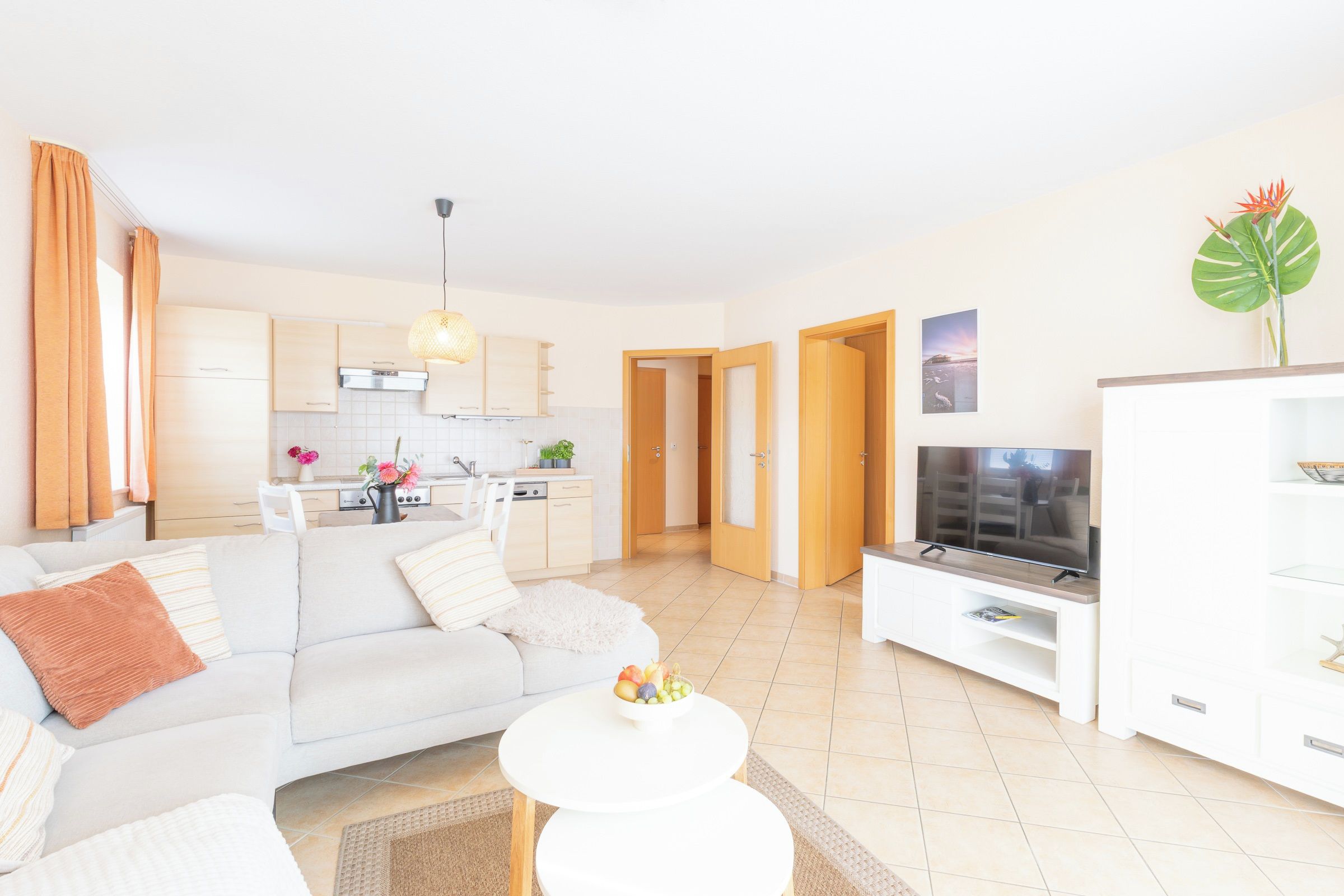Een moderne woonkamer met een bank, een salontafel en een televisie op een dressoir.