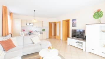 Een moderne woonkamer met een bank, een salontafel en een televisie op een dressoir.