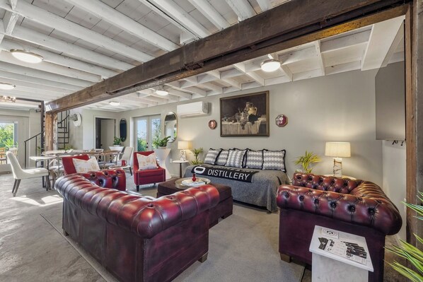A spacious living area with leather sofas, a coffee table, and a fireplace.