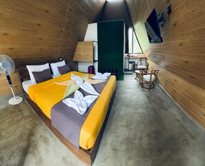 A compact room with a bed, a desk, a chair, and a fan. - 7 Art Villa (ELLA)