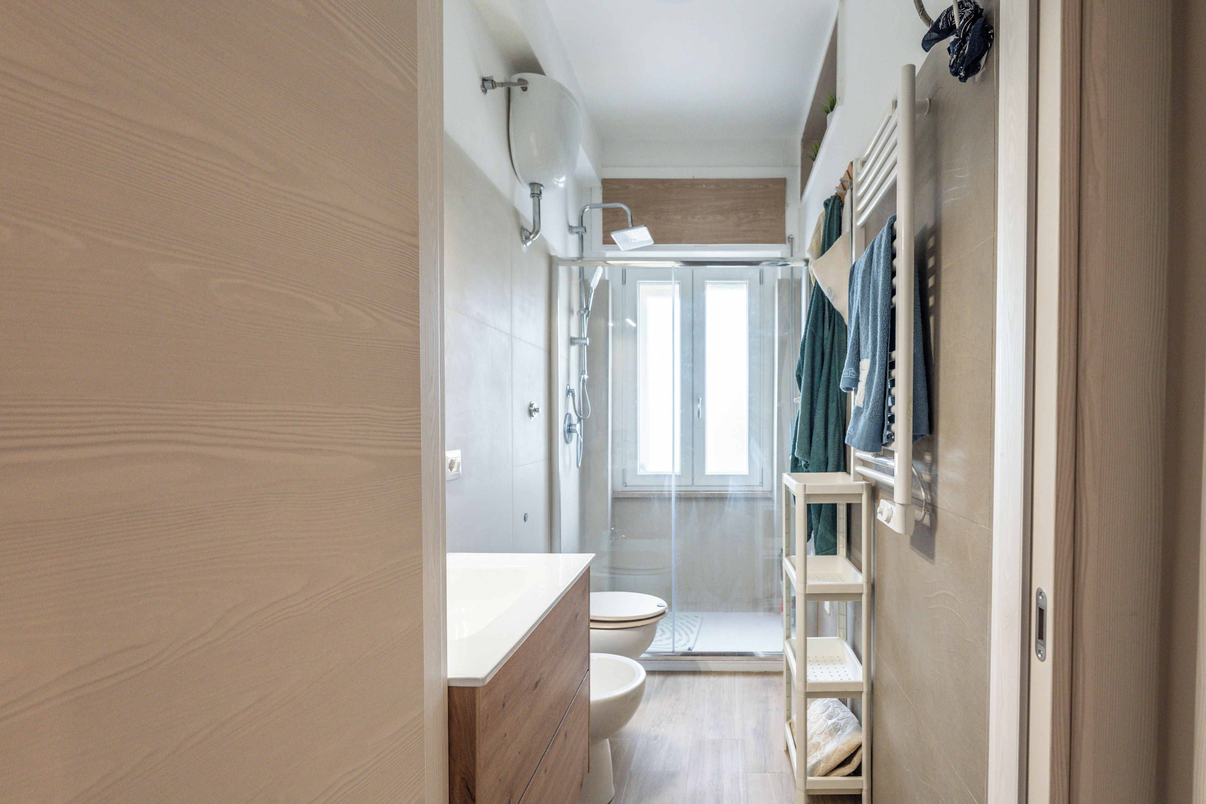 A modern bathroom with a shower, toilet, and a vanity.