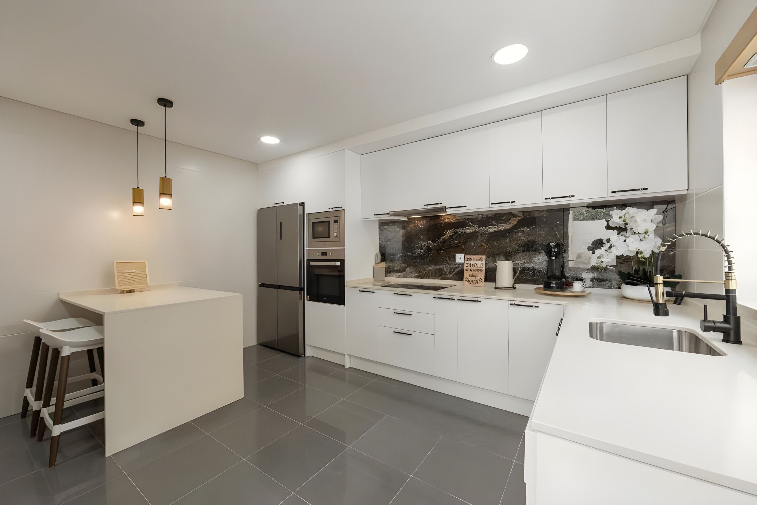 A modern kitchen with white cabinetry, stainless steel appliances, and a central island with stools.
