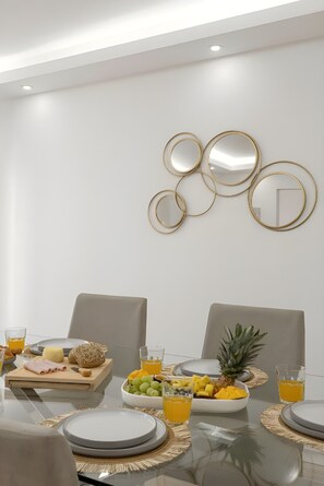 A dining area with a table set for two, featuring a fruit bowl, plates, and glasses. - GtHouse's Atlantic Coast Retreat   (Atouguia da Baleia)