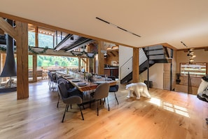 A spacious dining area with a long wooden table set for a meal, surrounded by chairs. - New Listing (La Clusaz)