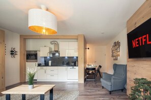 A modern kitchen with white cabinets, a built-in oven, and a hanging light fixture. - Pool & sauna, forest view · #16 (Winterberg)