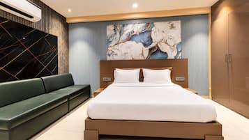 A modern bedroom with a bed, a green sofa, and a marble wall.