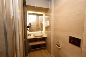 A modern bathroom with a sink, mirror, towel rack, and a toilet paper holder. - The Diamond City Hotel Yenikapi (Fatih)