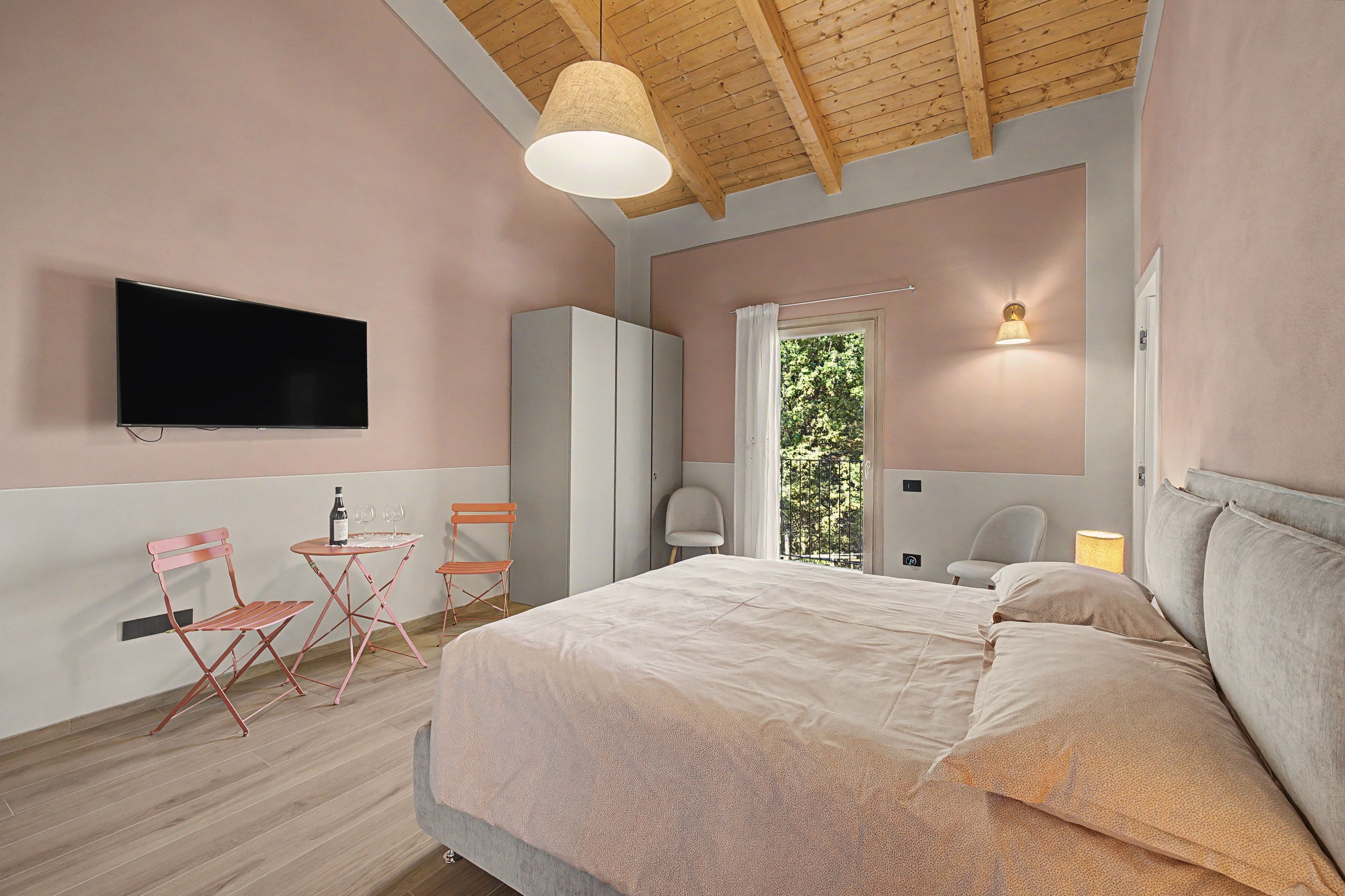 Une chambre à coucher avec un lit, une télévision, une armoire, une chaise et une table.