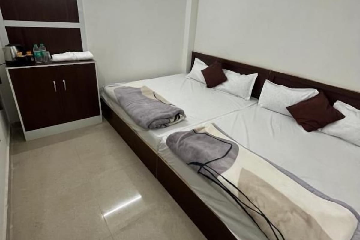 A single bed with a wooden headboard, a bedside table with a lamp, and a wardrobe with a mirror.