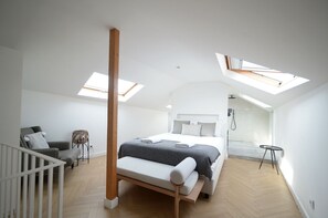 A modern bedroom with a skylight, a bed, a chair, and a small table. - New Listing (Lisboa)