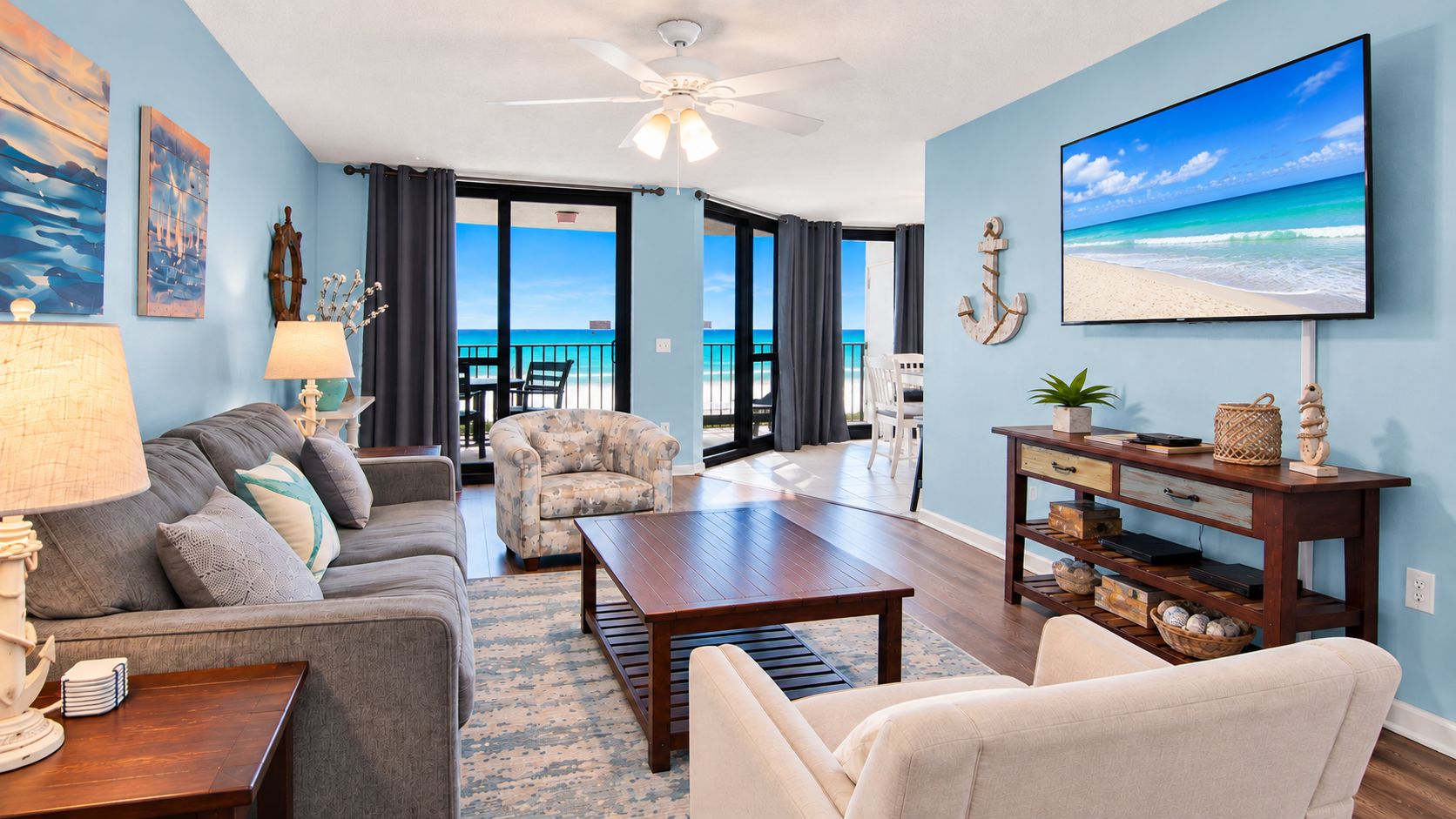 A living room with a sofa, armchair, coffee table, and a television on a stand.