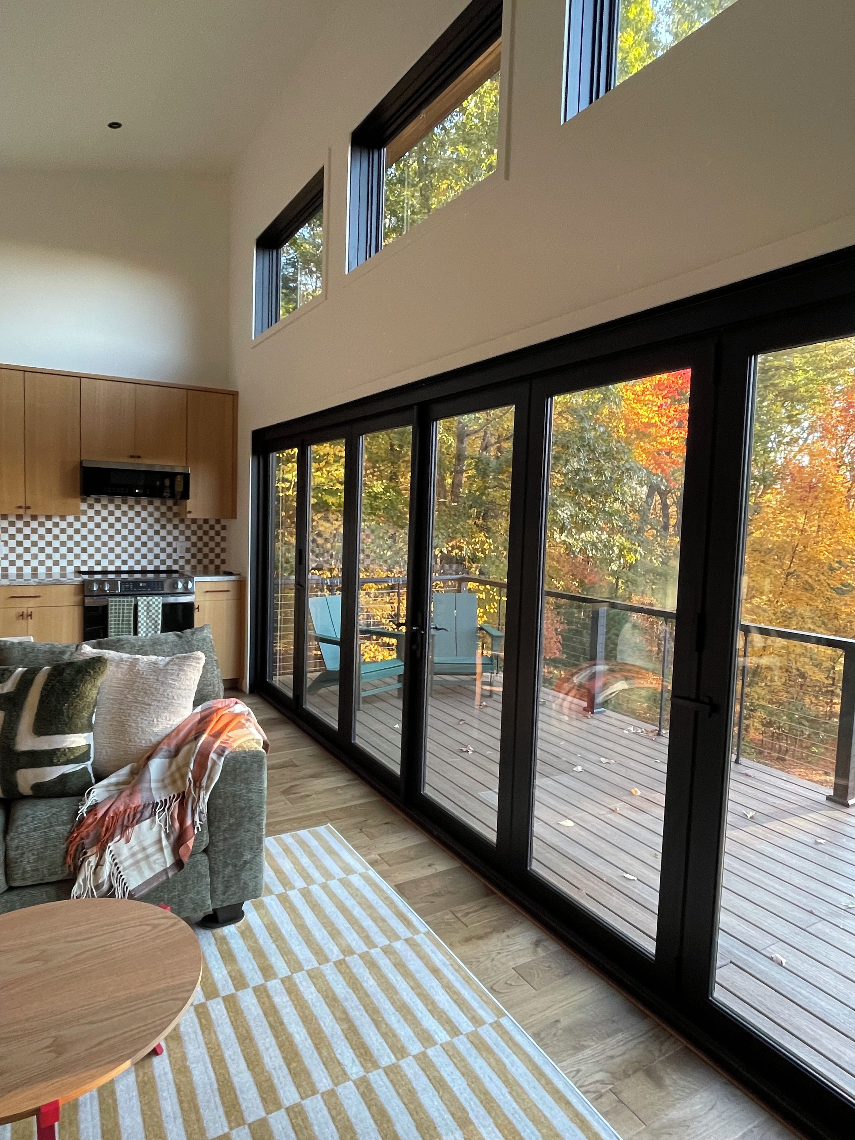 A modern interior with a sofa, a dining table, and a kitchen area.