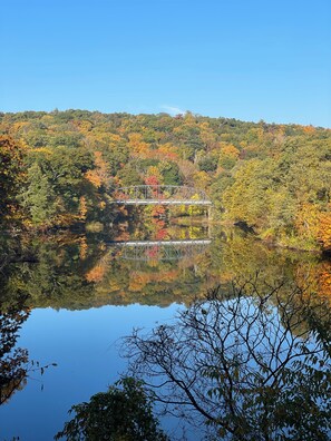 Un pont sobre un llac tranquil envoltat de fullatge d'octubre.