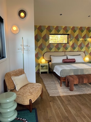 Une chambre à coucher avec un lit, des tables de chevet, une chaise, une lampe sur pied et une fenêtre.