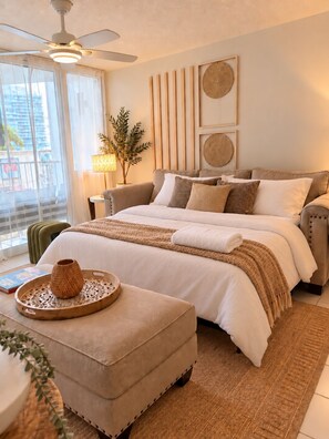 A modern bedroom with a bed, a bedside table, a lamp, and a view of the outside. - COCO • Suite with Beach Access & Pool @ Isla Verde (Carolina)