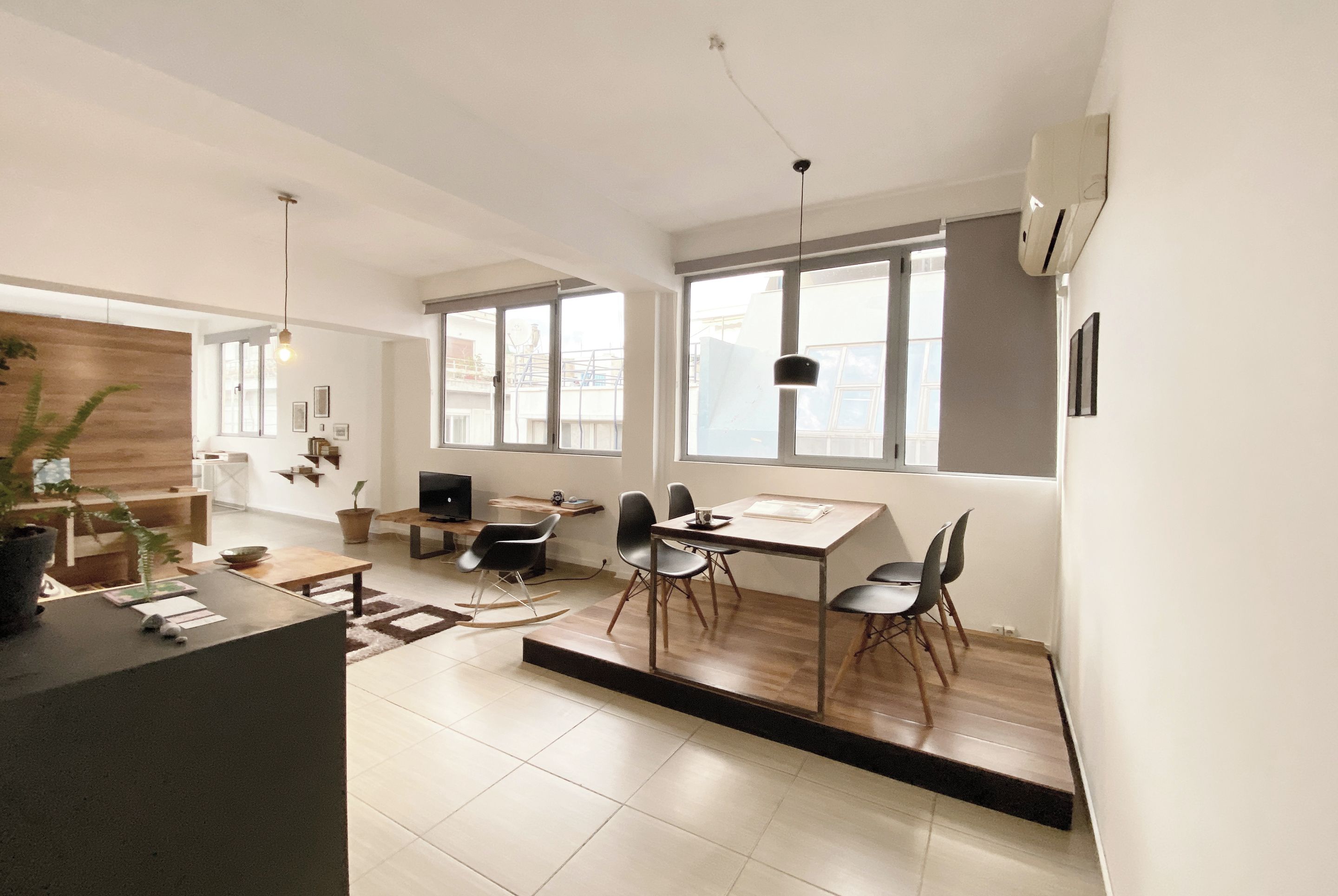 A modern kitchen with a dining area, large windows, and a view of the city.