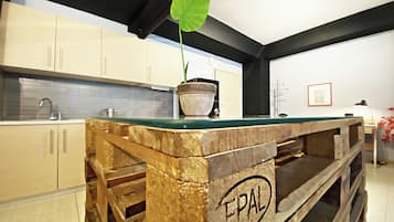 Una cucina con isola in legno, una pianta in vaso e uno schienale piastrellato.