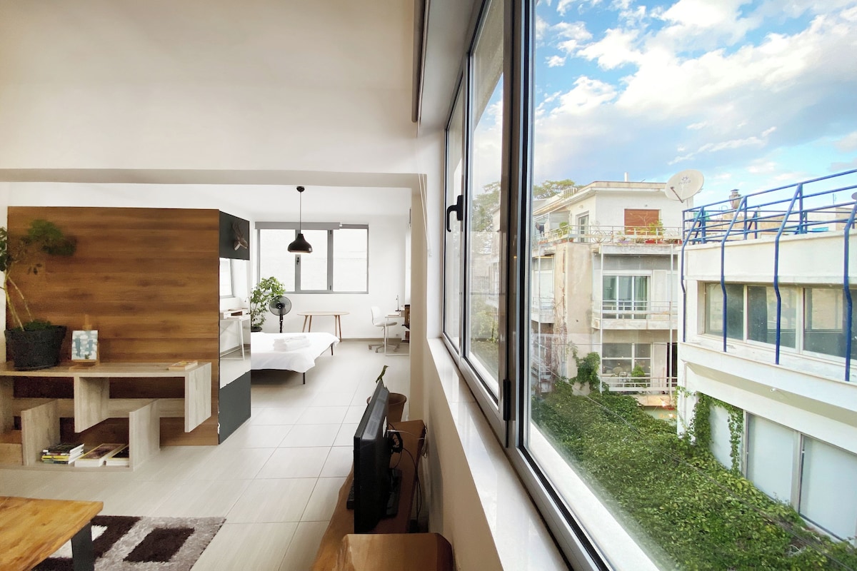 Een modern interieur met een eethoek, een keuken en een groot raam met uitzicht op de stad.
