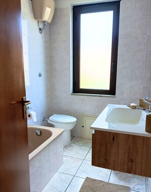 Une salle de bain avec une baignoire, des toilettes et un lavabo.