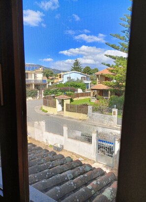 Área residencial com casas, rua e portão.