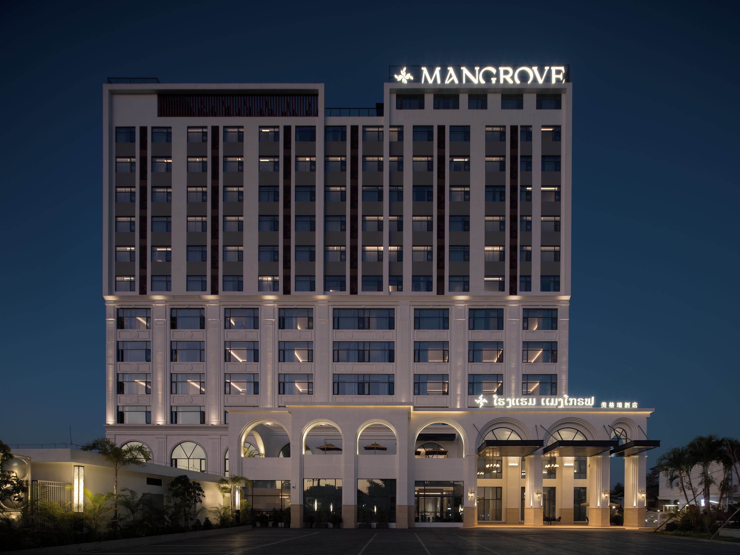 A multi-story hotel with a prominent signage, a series of windows, and an entrance with a covered area.