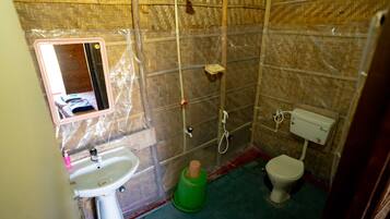 A bathroom with a sink, toilet, and shower area.