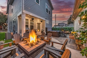 A patio with a fire pit, outdoor seating, and a view of a house. - The Savoy Art Deco Luxury Hot Tub (Wilmington)