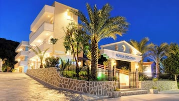 Un immeuble à plusieurs étages, doté d’une façade en pierre et d’une enseigne indiquant « FARKIA EXCLUSIVE ».