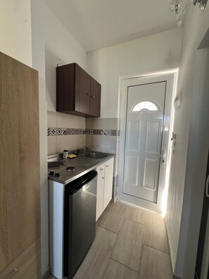 A compact kitchen with a built-in dishwasher, a stove, and a sink. - EO Rodou Lindou 407 (Faliraki)