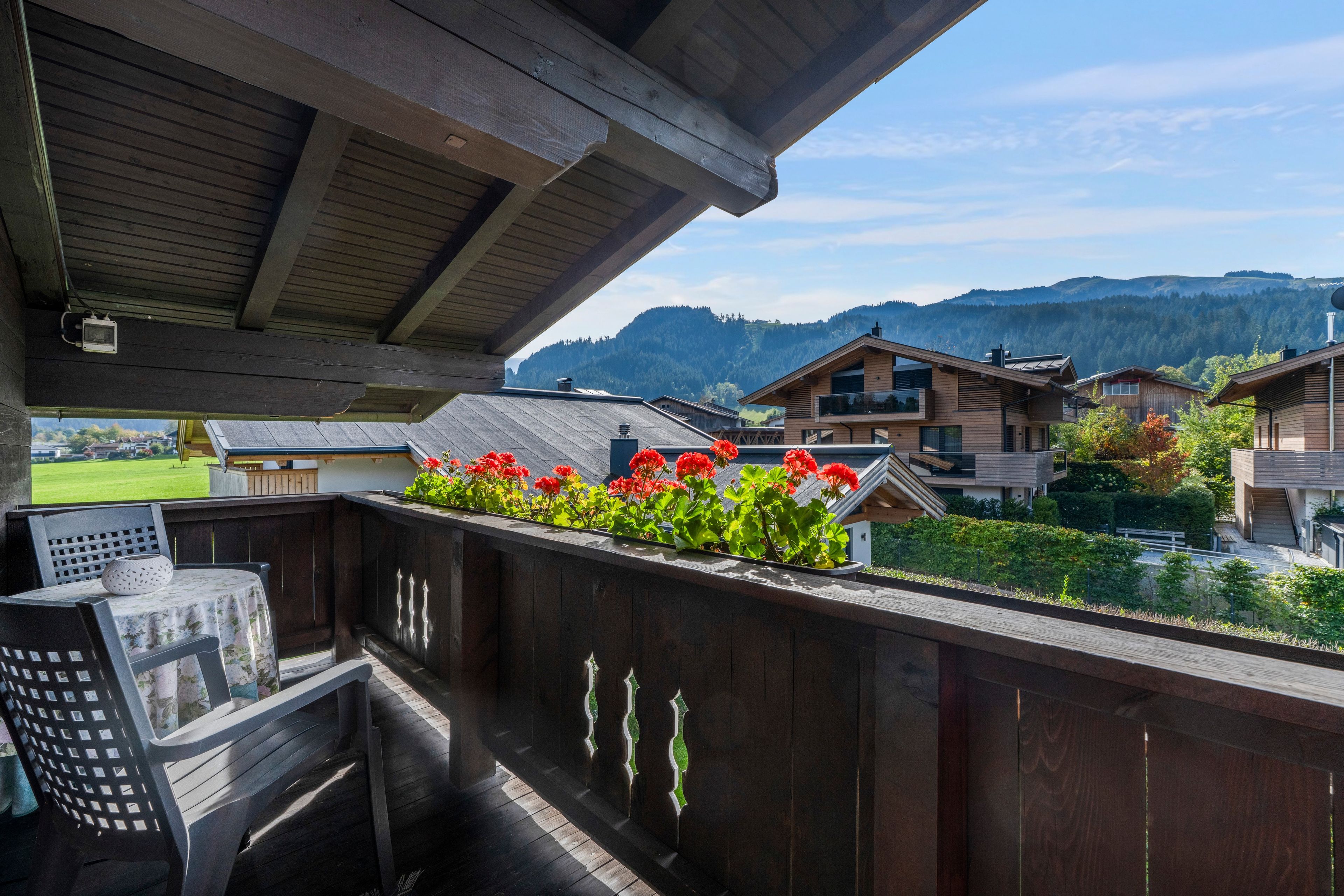 Ein Holzbalkon mit Blick auf Häuser und Berge.