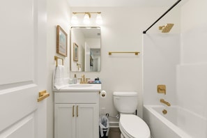 Un baño con lavamanos blanco, inodoro, bañera y ducha.