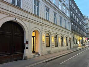 Un edificio con grandes ventanales de arco y una entrada destacada con escalones.